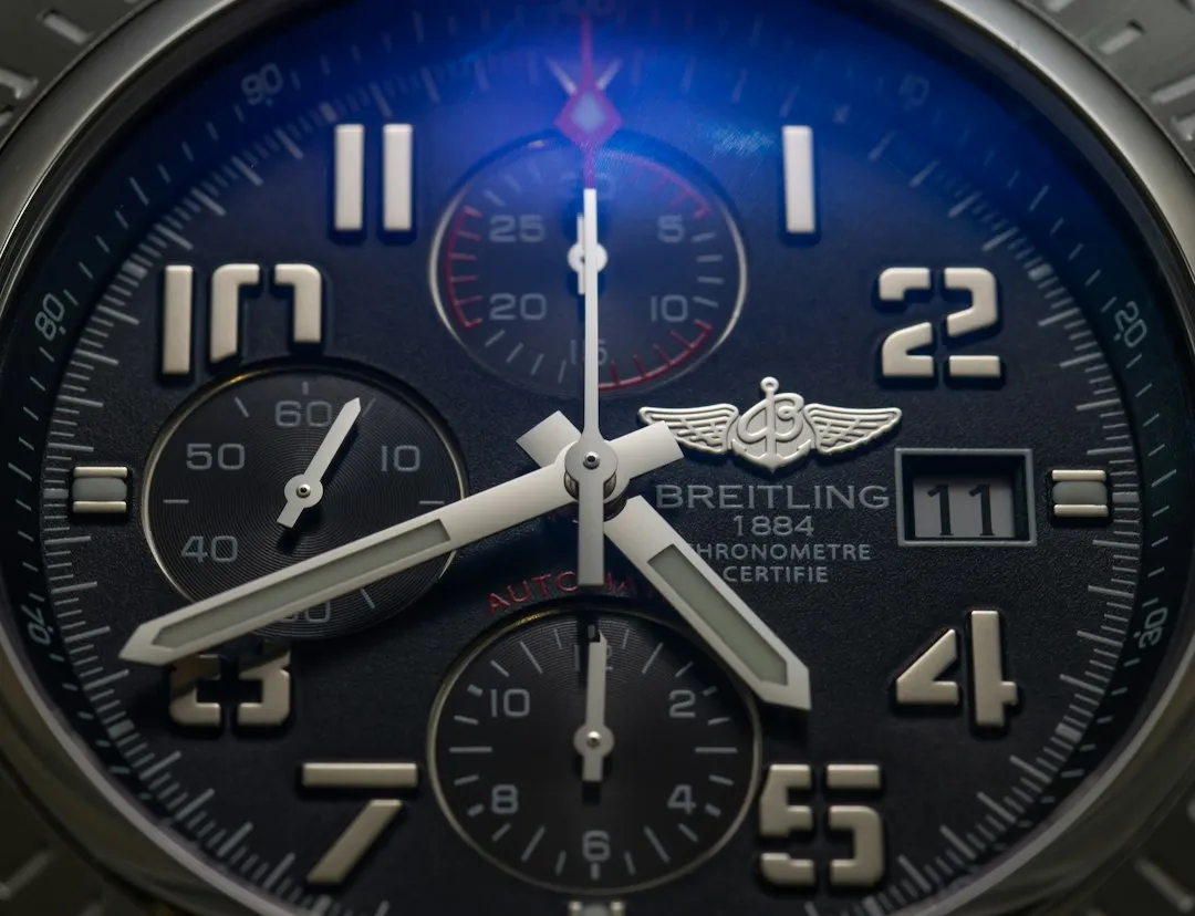Close-up of a black Breitling Navitimer watch face featuring chronograph subdials and the winged brand logo.