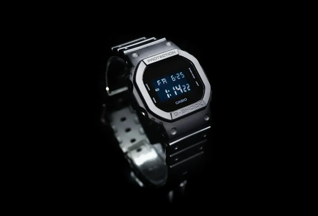 A silver Casio G-Shock square digital watch photographed against a black background.