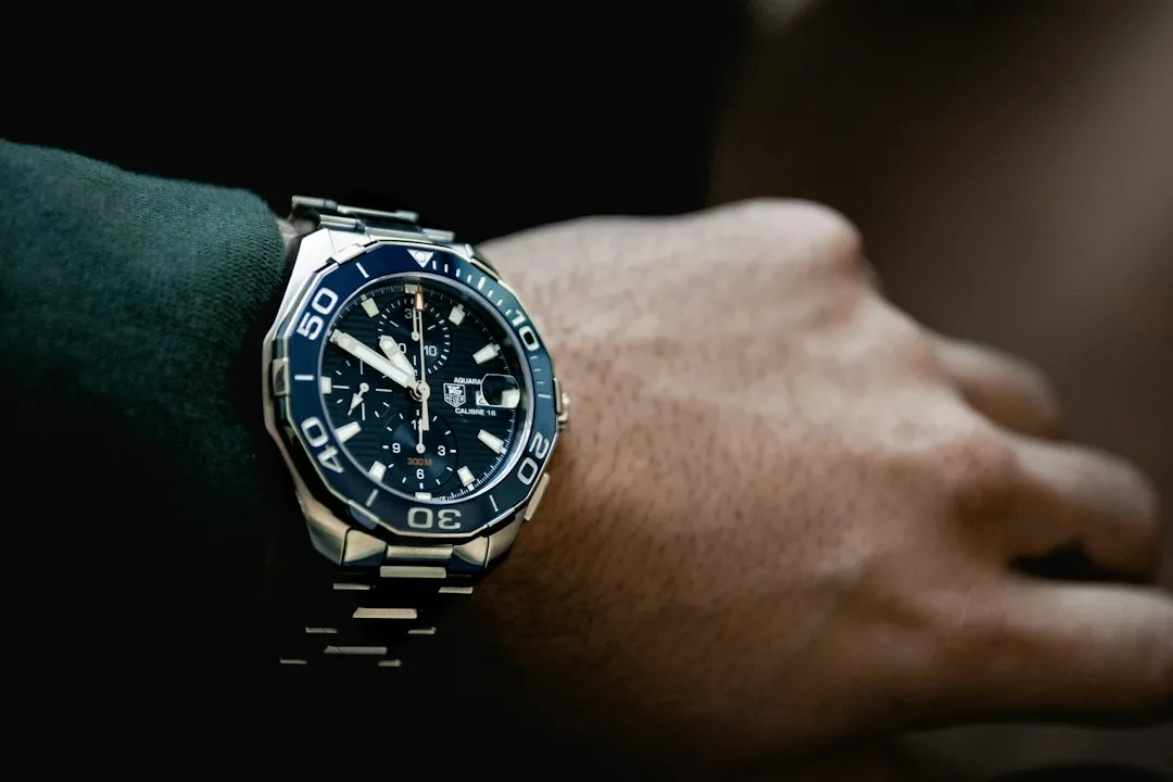 A close-up of a silver wristwatch with a blue dial worn on a person's wrist.