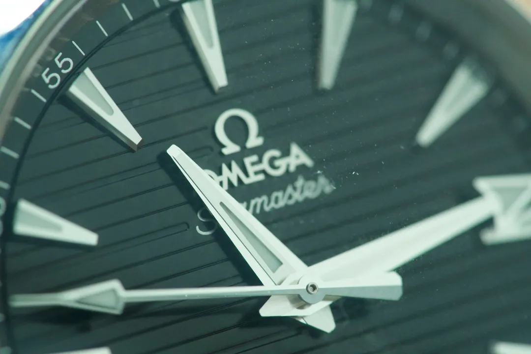 Primer plano de la esfera de un reloj Omega Seamaster que muestra el logotipo de la marca y las manecillas blancas.