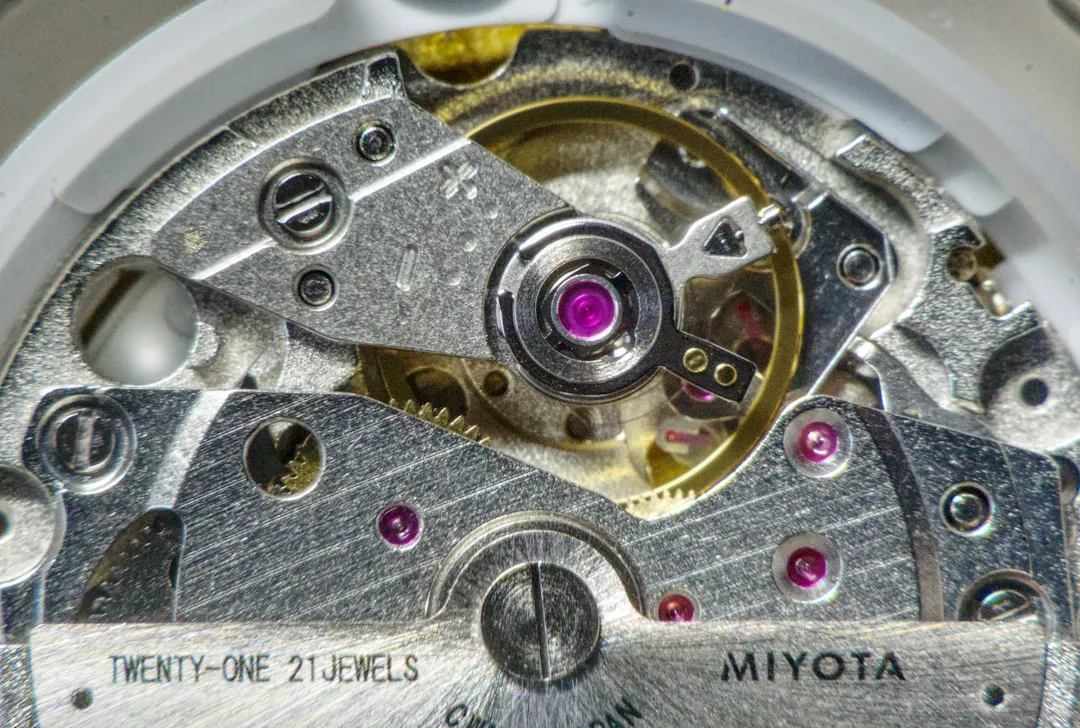 A close-up view of a mechanical watch movement revealing the balance wheel and gears.