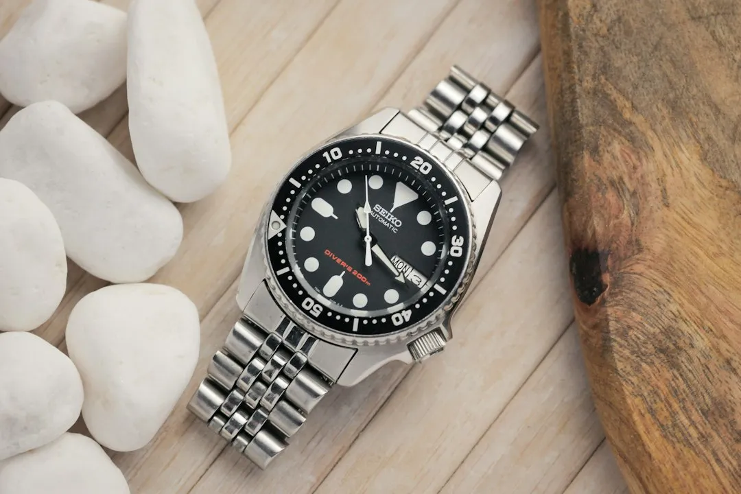 A silver Seiko diver's watch with a black dial and bezel on a metal bracelet.