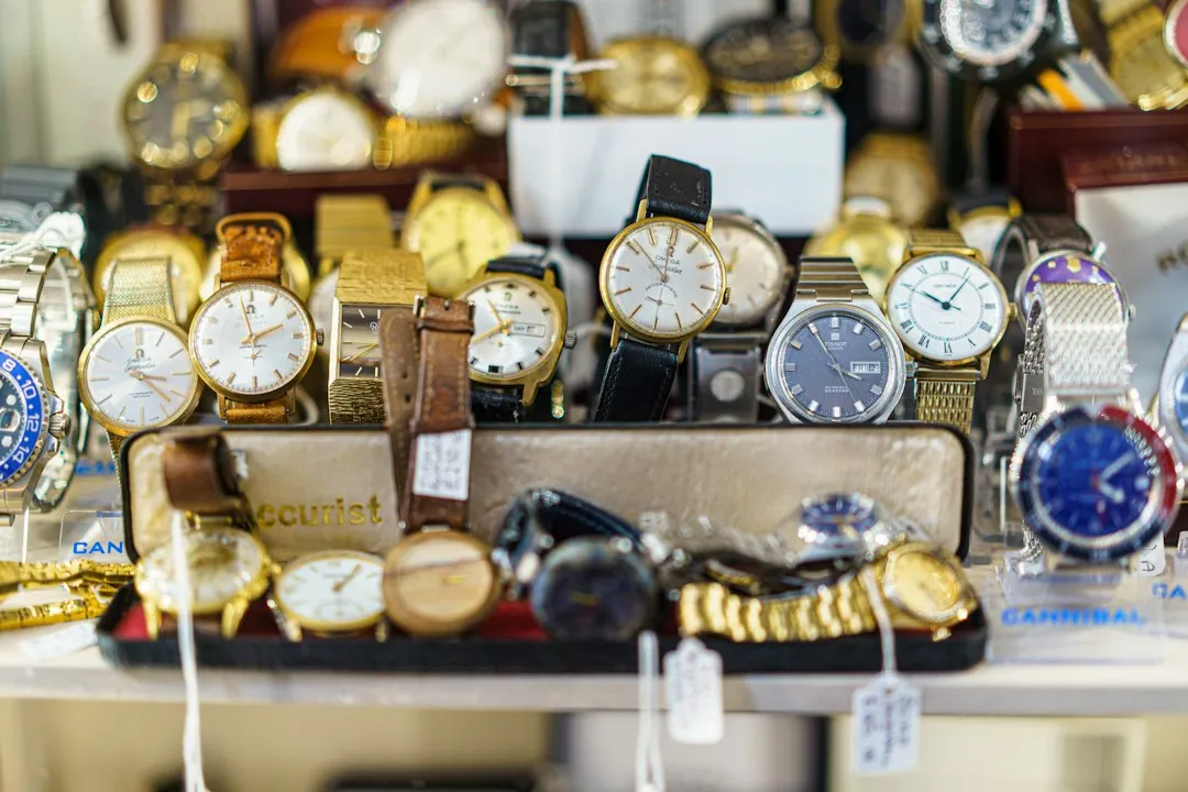 A glass display case filled with various wristwatches and price tags in a shop.