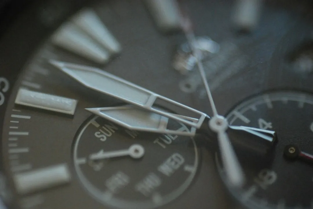 A close-up view of a watch dial featuring hour markers and a day-of-the-week subdial.