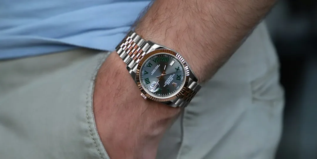 A close-up of a stainless steel Rolex GMT-Master II watch with a two-tone bezel worn on a wrist.