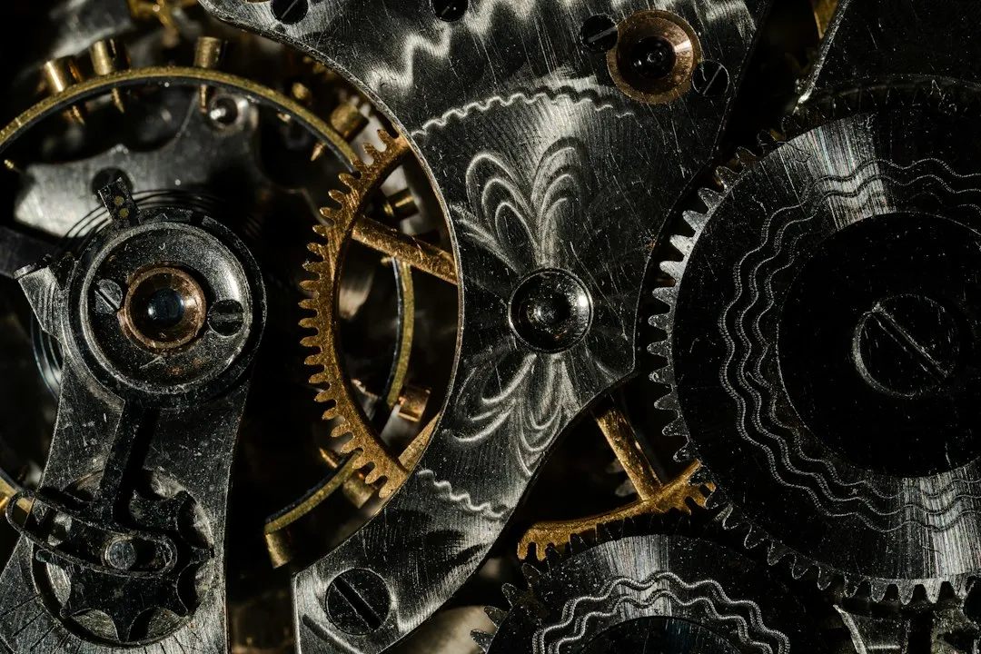 A close-up view of decorated mechanical watch movement gears and bridges with intricate patterns.