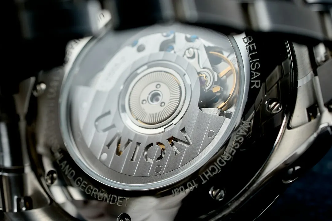 Close-up view of a watch case back revealing a rotor engraved with the Zenith brand name.