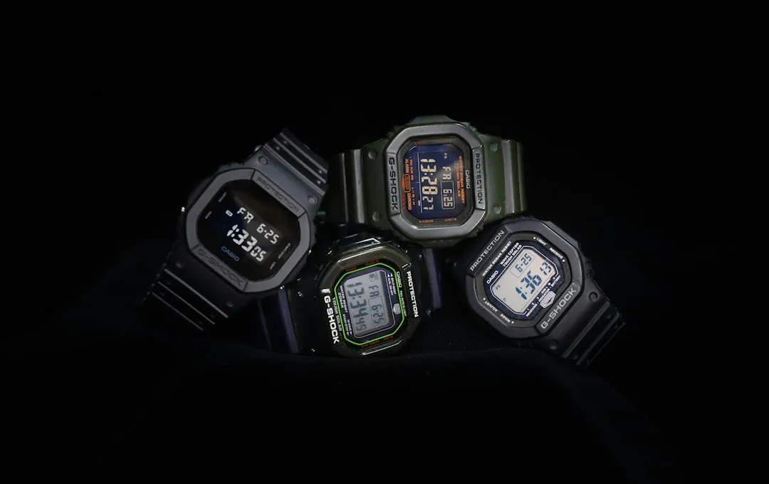 Four Casio G-Shock digital watches with square cases arranged together on a black background.