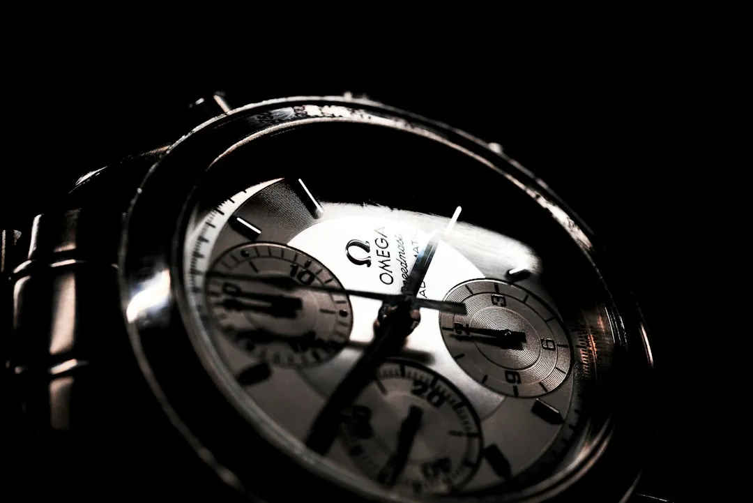 A close-up shot of an Omega Speedmaster chronograph dial with visible branding and subdials.