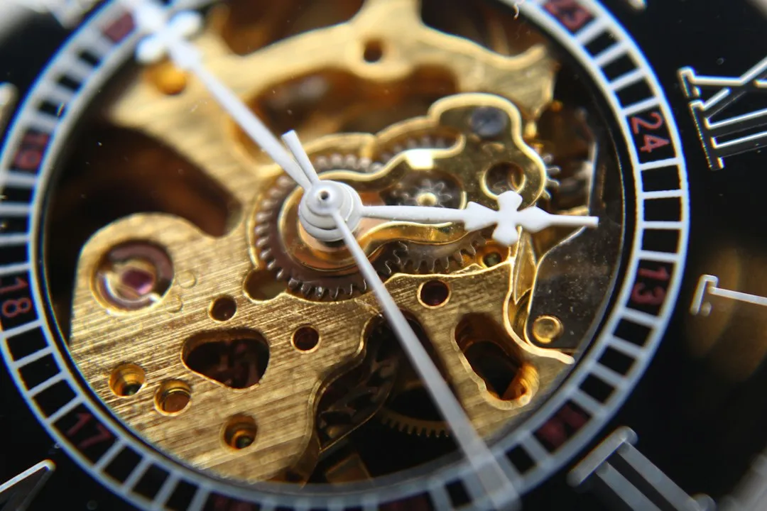 Close-up of a wristwatch dial featuring an open-heart cutout revealing the golden gears and movement underneath.