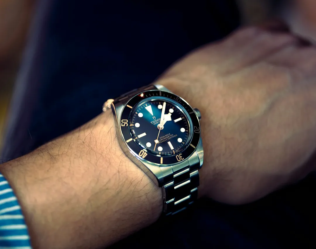 A close-up of a Tudor Black Bay watch with a blue dial worn on a wrist.