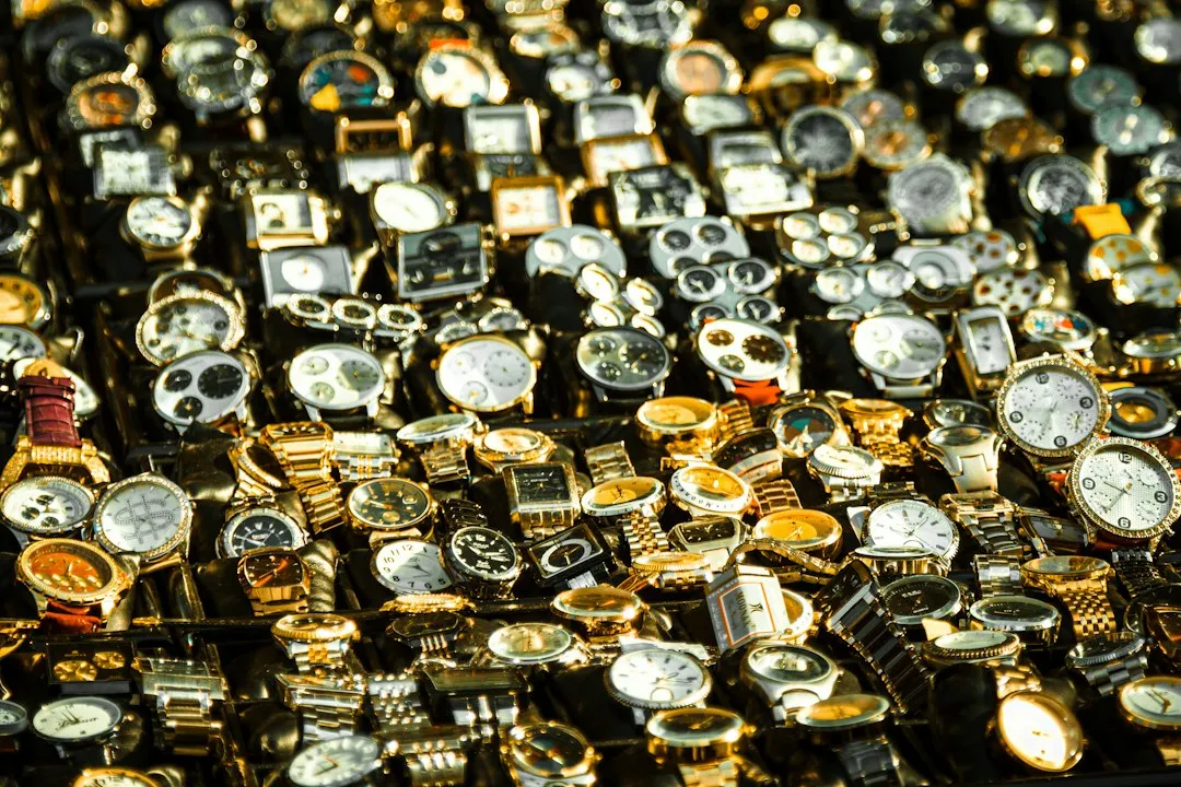A dense collection of numerous wristwatches displayed closely together on a surface.