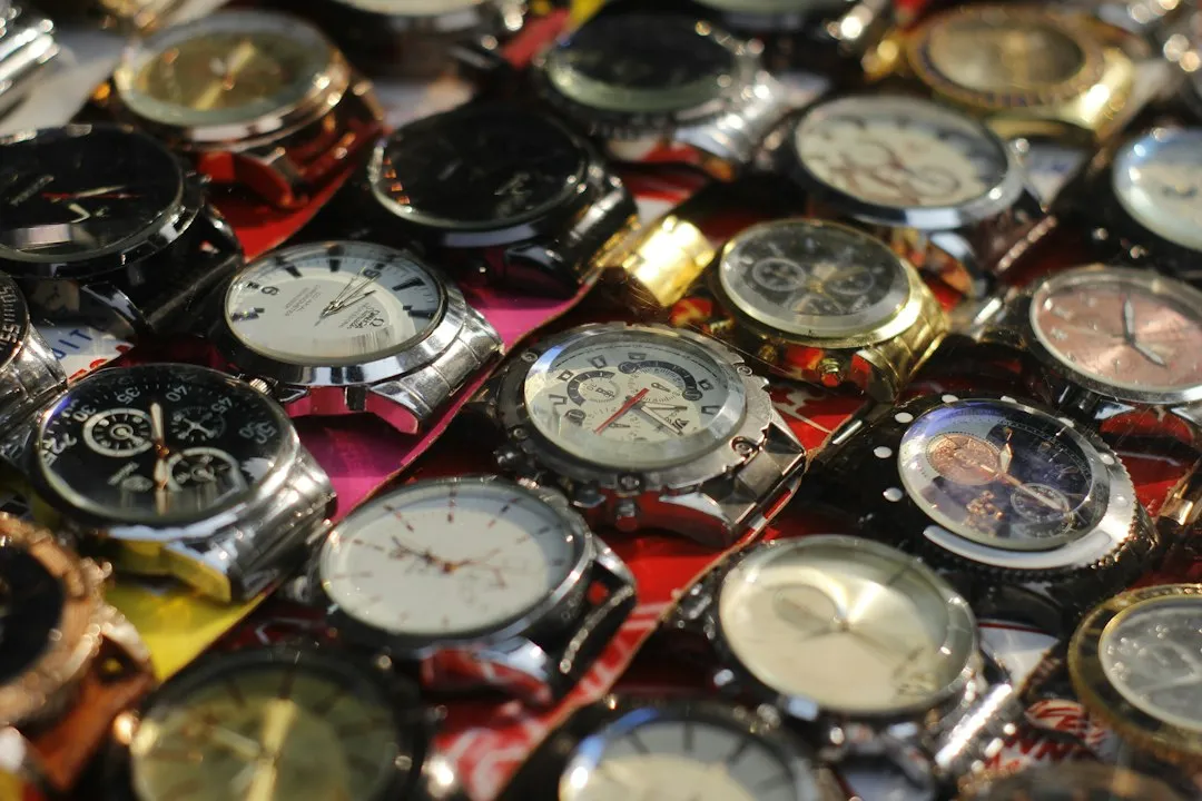 A large pile of assorted wristwatches with various dial colors and case materials.