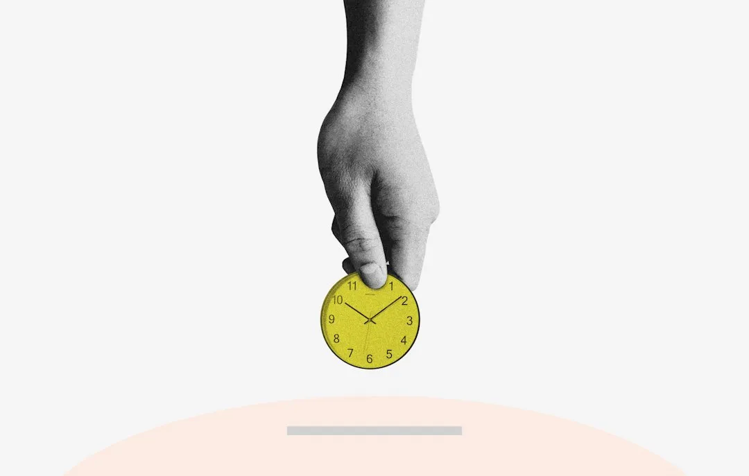 A hand holds a yellow watch face while adjusting the crown to set the time.